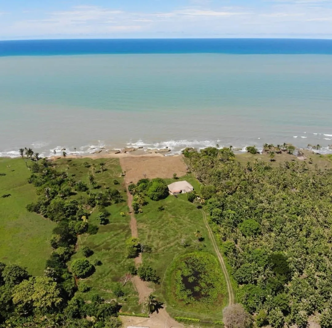 Vista aérea del lote de Avista Beach con la laguna, la vía interna y el mar Caribe al fondo