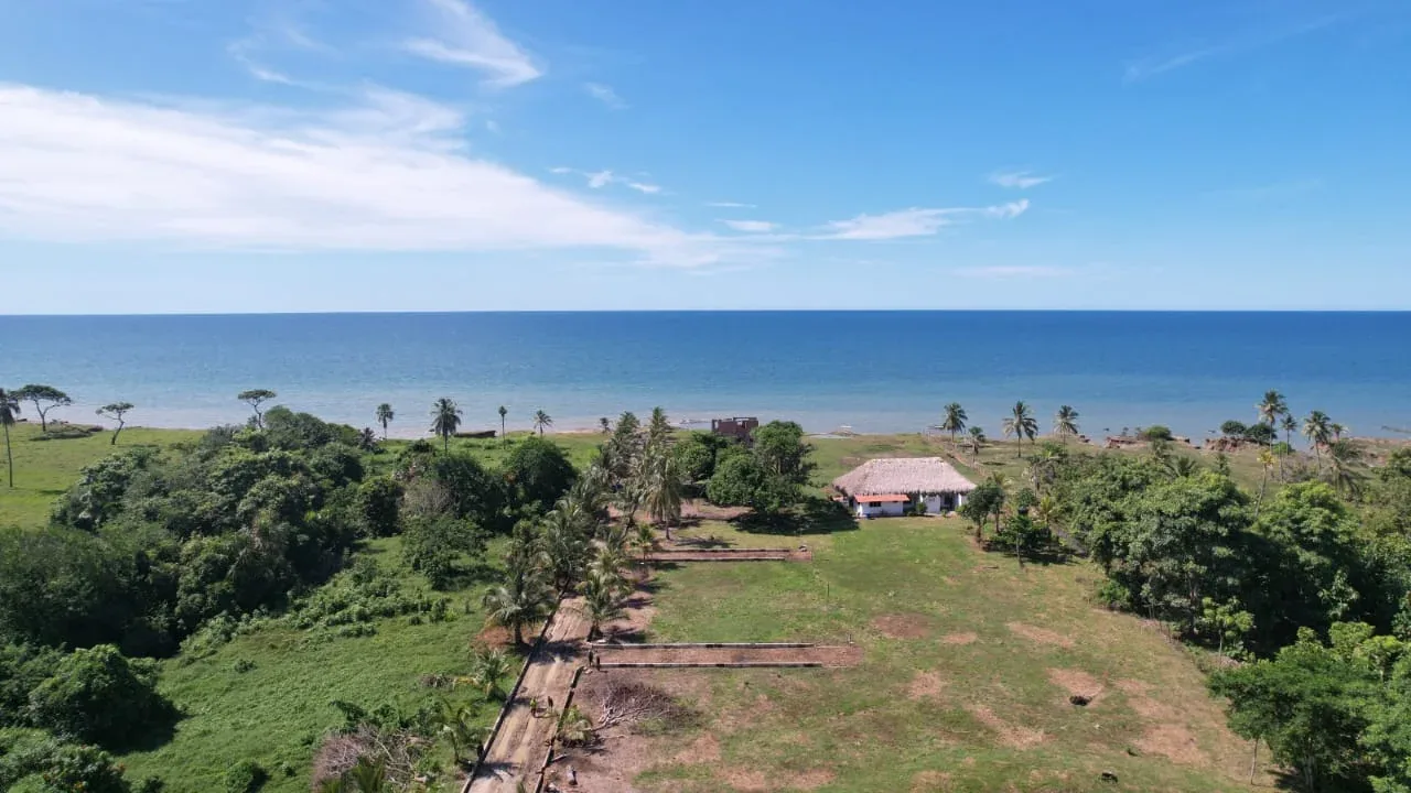 Toma de dron del frente de playa con la vía interna trazada y la villa tradicional existente